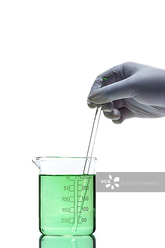 手持玻璃搅拌棒在烧杯中搅拌绿色液体图片素材