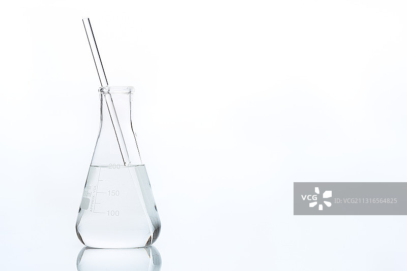 锥形瓶中带有玻璃搅拌棒的透明液体图片素材