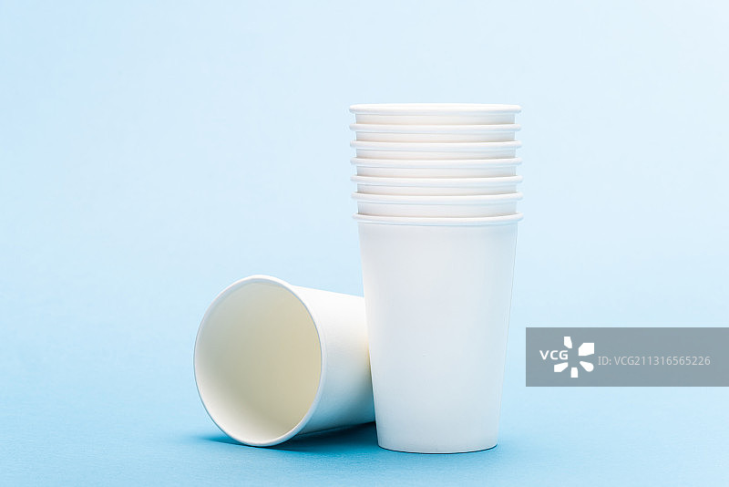 叠放的纸杯，蓝色背景图片素材