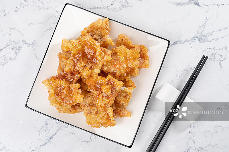 大理石桌子上中国东北传统家宴菜油炸一碟酸甜美味锅包肉图片素材