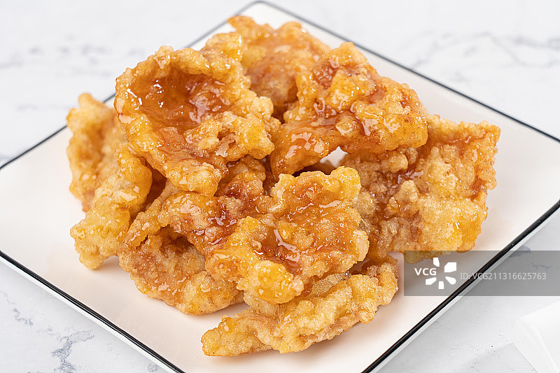 大理石桌子上中国东北传统家宴菜油炸一碟酸甜美味锅包肉图片素材