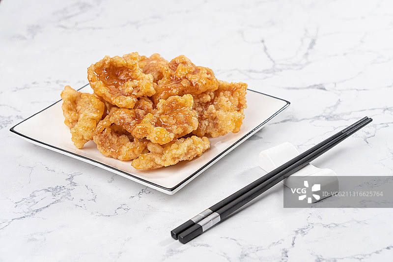 大理石桌子上中国东北传统家宴菜油炸一碟酸甜美味锅包肉图片素材