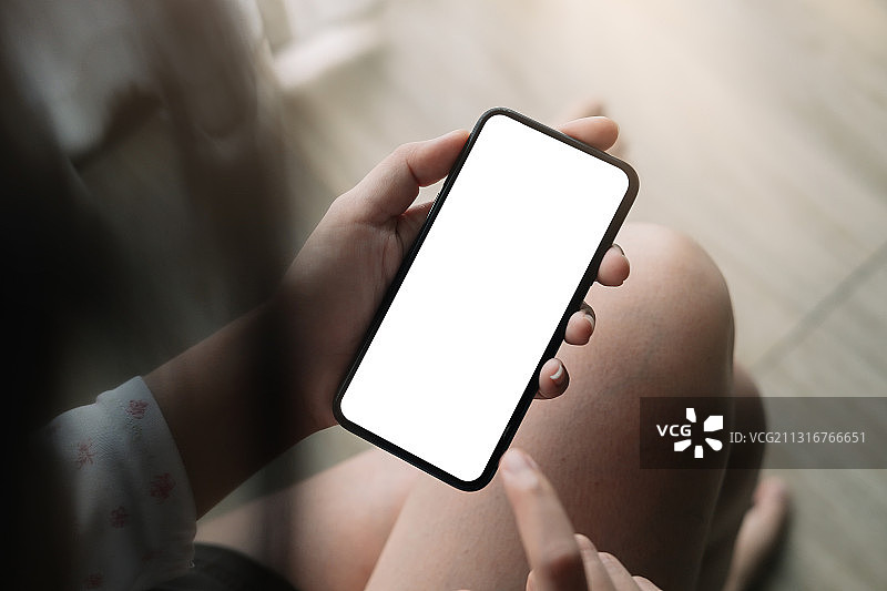 使用带空白屏幕手机的女性（高角度拍摄）图片素材