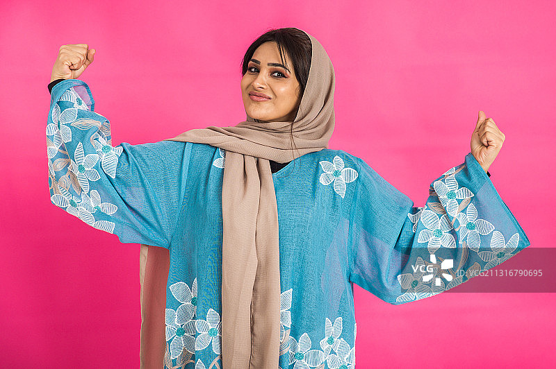 站在粉色背景前做手势的女性肖像图片素材