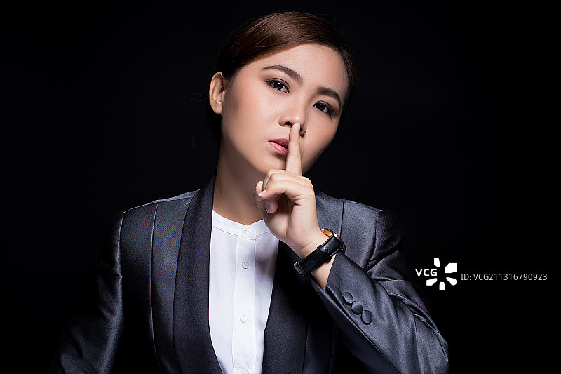 黑色背景下的年轻女商人肖像图片素材
