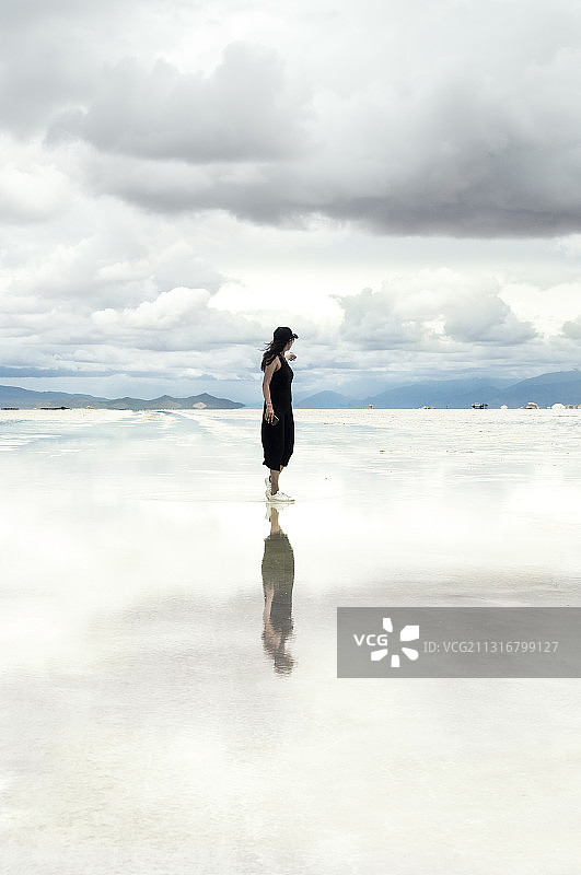 女子站在阿根廷萨尔塔省萨利纳斯格兰德斯盐滩上图片素材