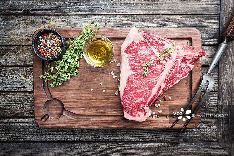 带香料的T骨牛排生肉在砧板上的俯视图图片素材