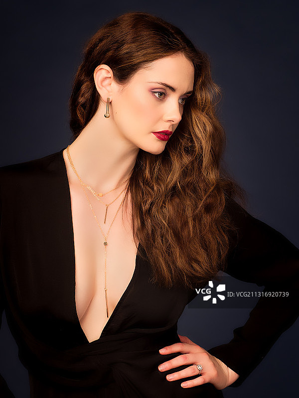 长发美女站在黑色背景前，英国布伦特福德图片素材