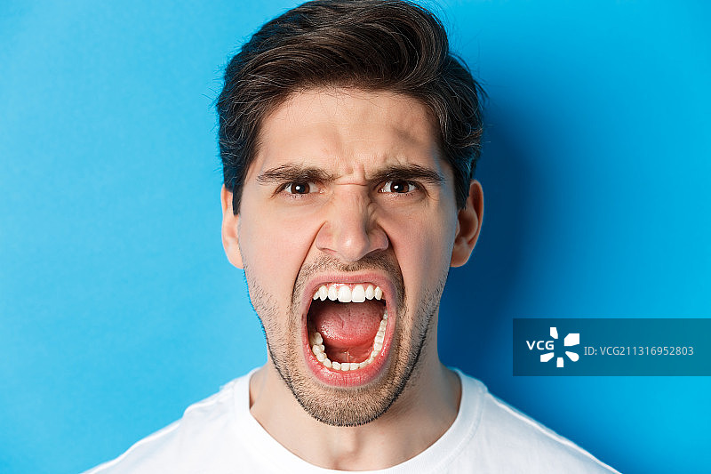 蓝色背景下震惊的男人肖像图片素材