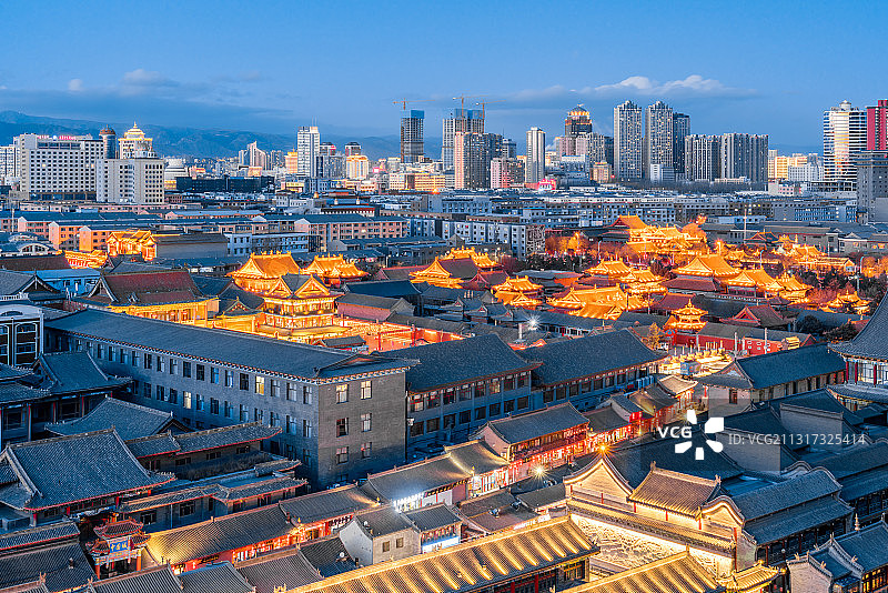 中国内蒙古呼和浩特大召寺、塞上老街和远处的高楼夜景图片素材
