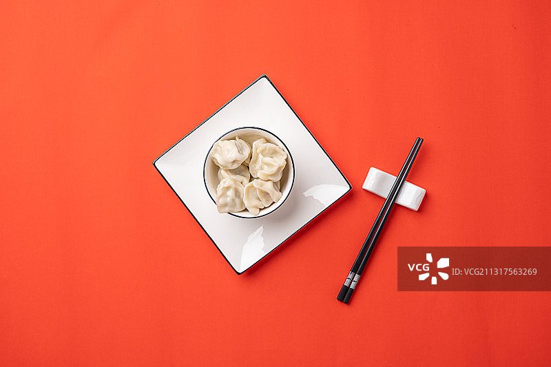 红色背景节日气氛喜庆概念一碗刚煮熟的饺子图片素材