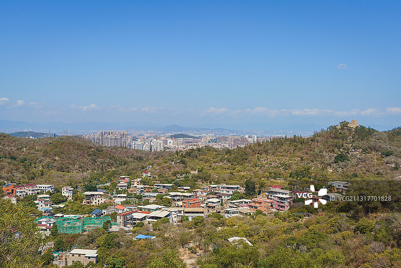 厦门东坪山上的小村庄和远处现代化城市天际线图片素材