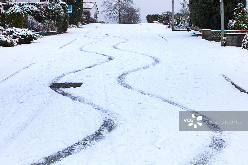 英国安布尔赛德陡峭道路上的汽车雪地轮胎痕迹图片素材