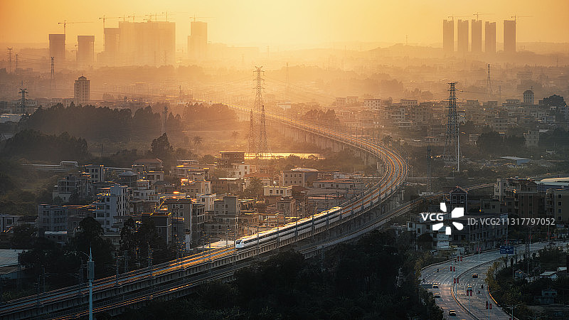 金色斜阳照耀在一辆高速行驶中的动车上图片素材