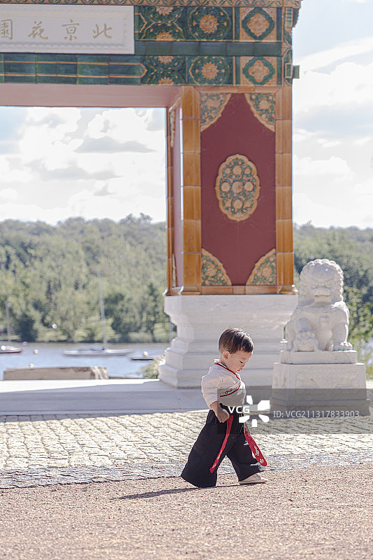 穿汉服的男婴在琉璃牌楼前图片素材