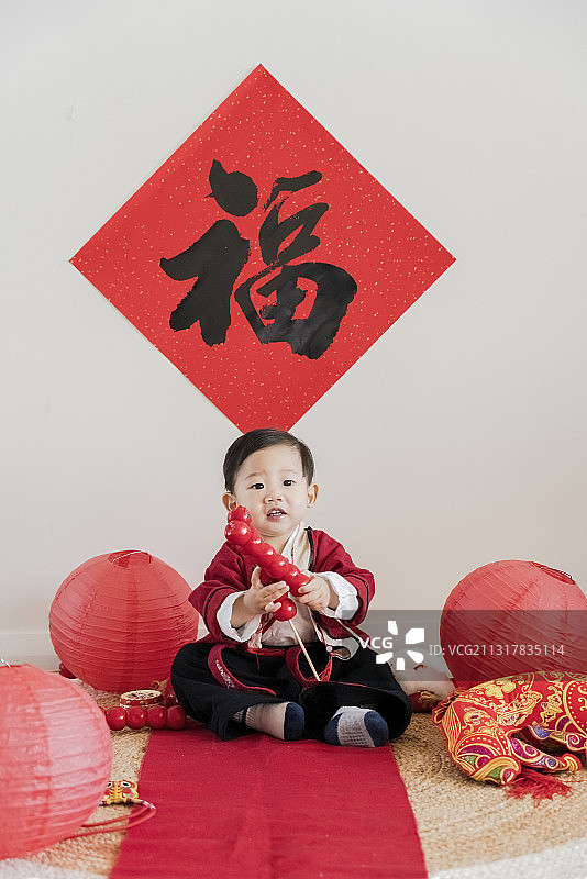 春节快乐地挥动冰糖葫芦串的红汉服男婴图片素材
