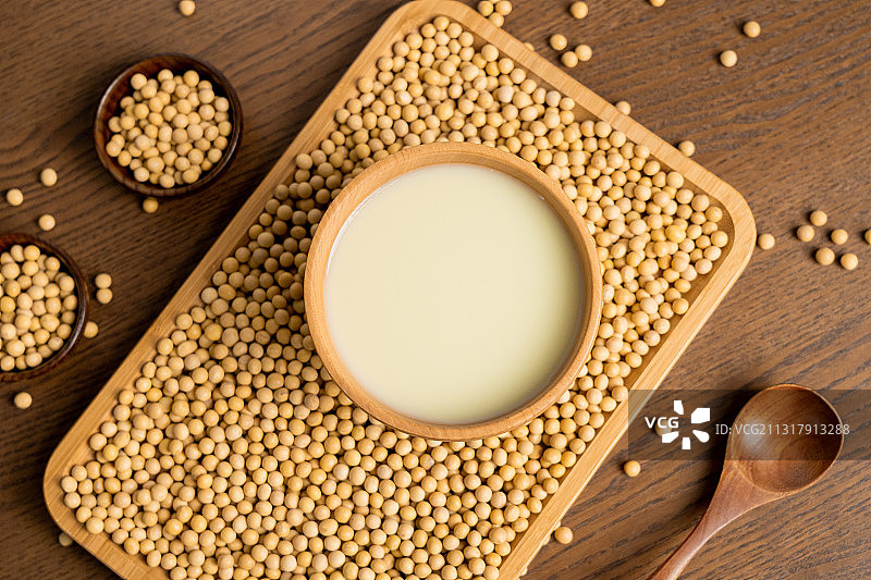 纯色桌子上碗里的早餐豆浆饮品和原材料黄豆图片素材