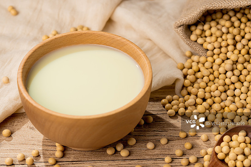 纯色桌子上碗里的早餐豆浆饮品和原材料黄豆图片素材