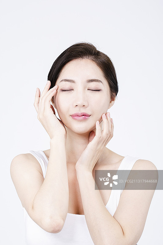 穿着白色无袖的美丽亚洲女性，白色背景美容化妆品概念图片素材