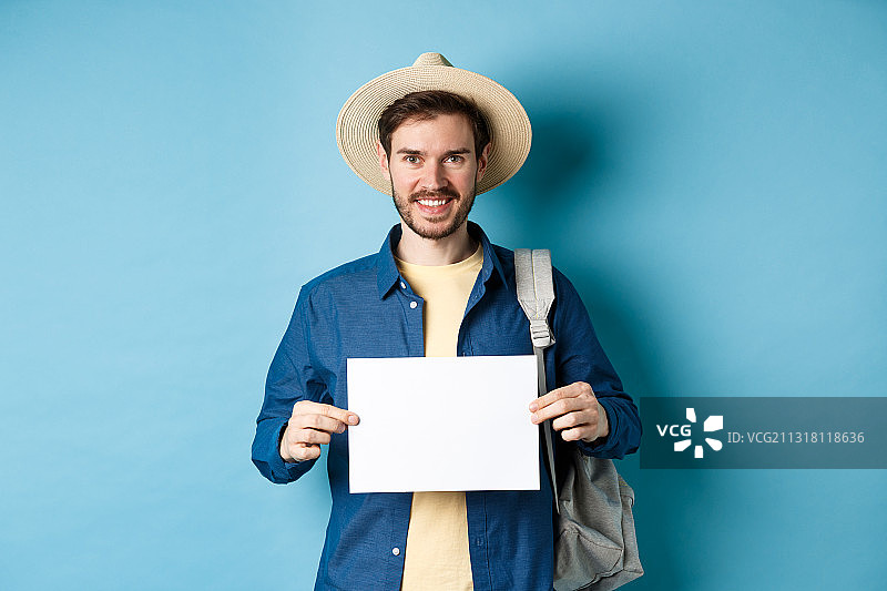 男子手持空白标语牌，背景为蓝色图片素材
