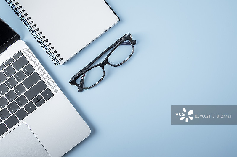 笔记本电脑上的空白笔记本和钢笔与眼镜，泰国曼谷图片素材