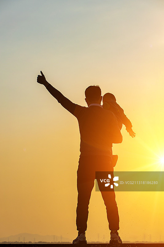 父亲抱着儿子看朝阳图片素材