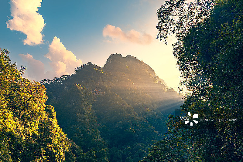 重庆万盛黑山谷景区-清晨的阳光穿过山坳照在树林上图片素材