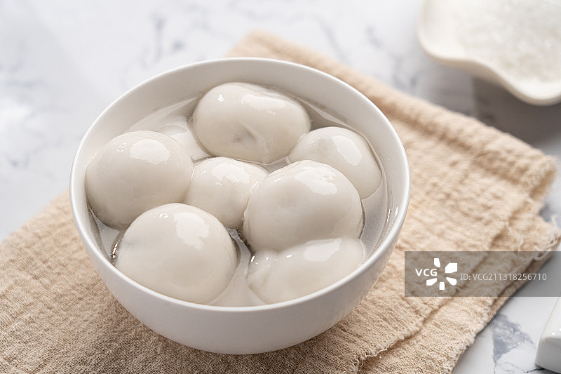 大理石背景亮调桌子上一碗煮熟美味的养生芝麻汤圆图片素材