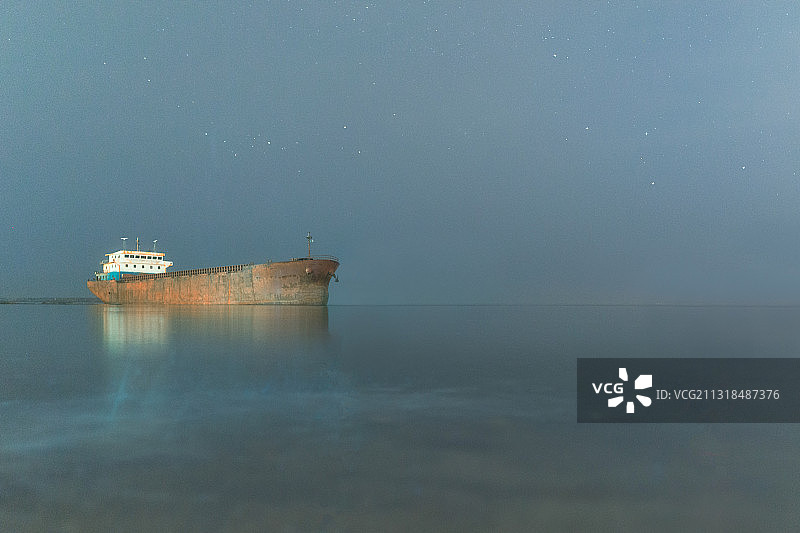 平静的海面上一艘搁浅的轮船图片素材