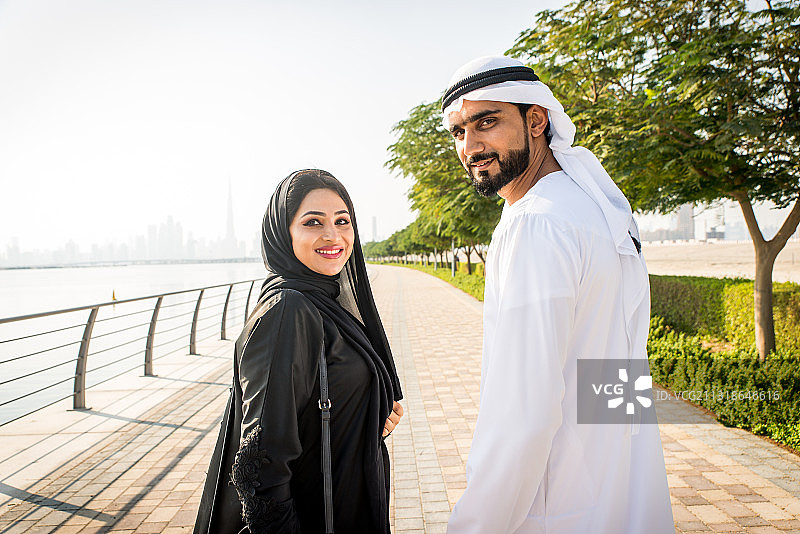 微笑情侣站在城市人行道上的肖像照，迪拜，阿拉伯联合酋长国图片素材