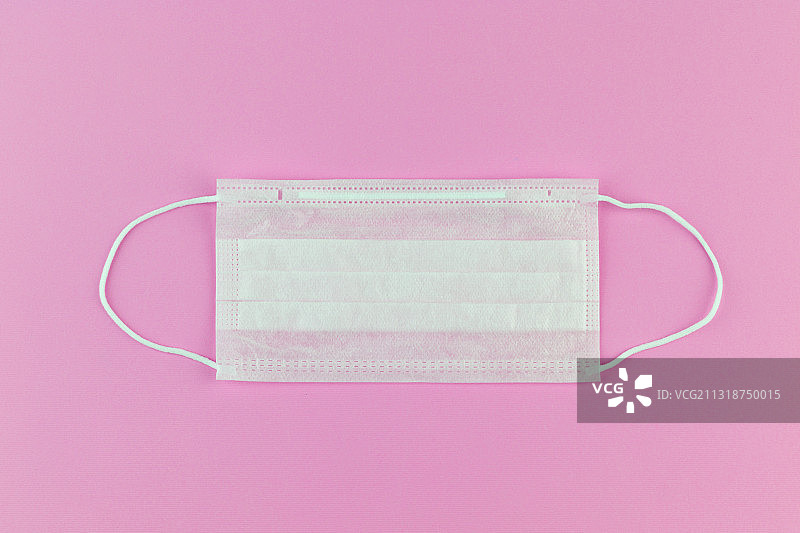 粉色背景上的一次性医用口罩图片素材