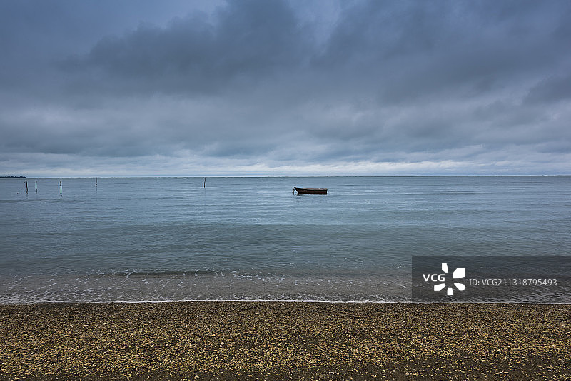 宁静的海面上漂着一只孤独的小渔船图片素材