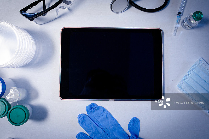 医生诊所的桌子，配有平板电脑、口罩、手套和听诊器图片素材
