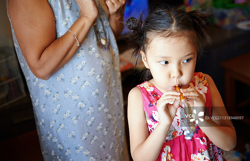 女孩在生日派对上吹喇叭图片素材