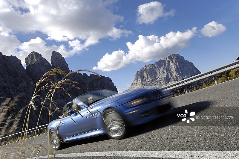 阳光下多洛米蒂山南蒂罗尔的蓝色敞篷车，意大利，欧洲图片素材
