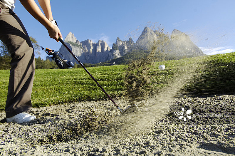 在意大利卡斯特尔鲁特阿尔卑斯山高尔夫球场击球的女人图片素材