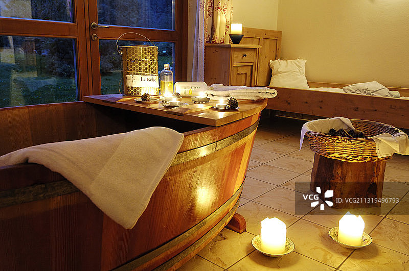 巴德舍尔高酒店水疗中心的木制浴缸和蜡烛，位于意大利南蒂罗尔萨恩塔尔山谷图片素材