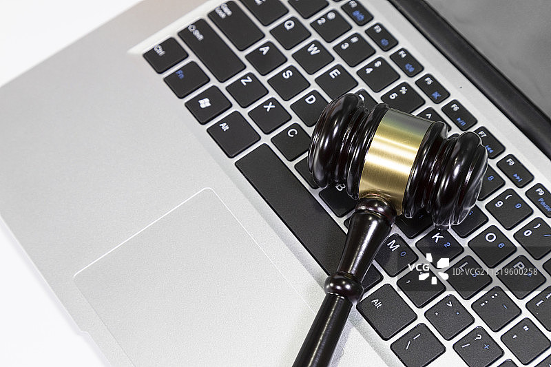 一把法槌在笔记本电脑旁图片素材