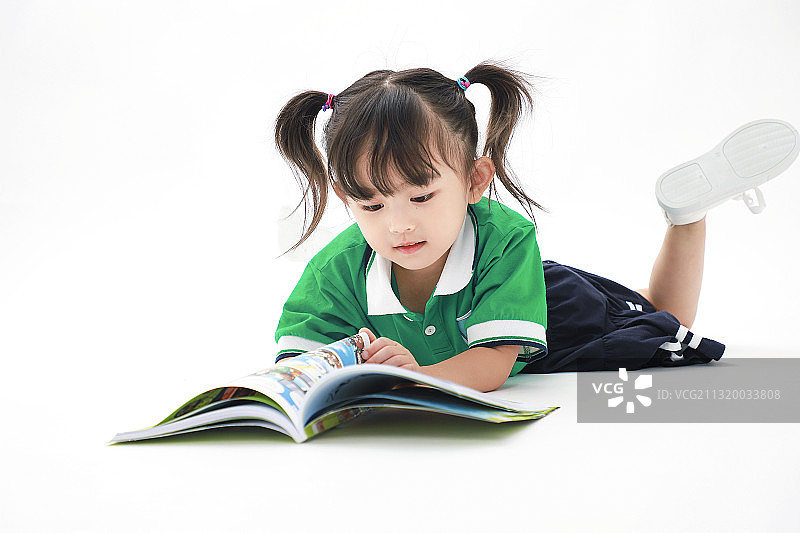 趴着看书的小女孩棚拍人像图片素材