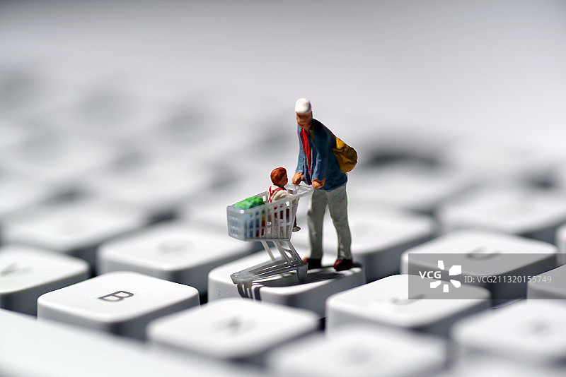 微缩人像白色键盘上推购物车图片素材