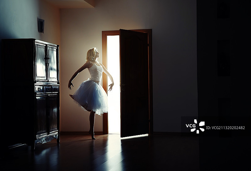 金发女人在黑暗的室内跳芭蕾舞图片素材