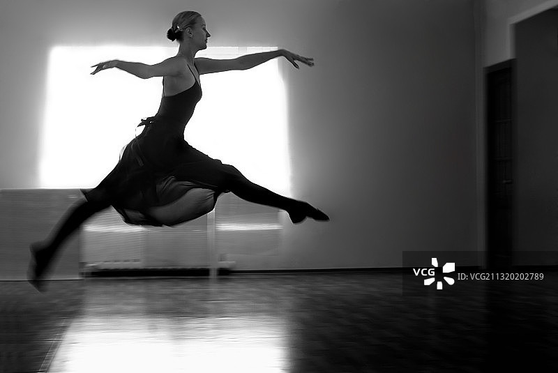 舞蹈室内跳跃的芭蕾舞女演员黑白照图片素材