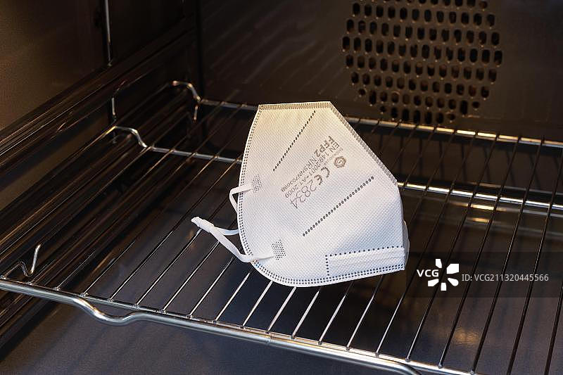 在烤箱中干燥以重复使用的FFP2口罩，强制佩戴口罩，预防新冠病毒感染，德国，欧洲图片素材