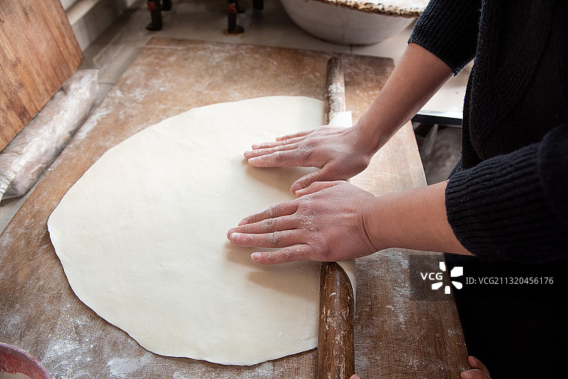 女性用擀面杖擀面团，面食制作图片素材