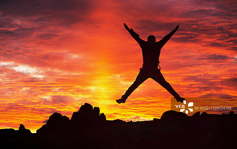 英国湖区安布尔塞德韦瑟拉姆山的日落云彩，一人喜悦跳跃图片素材