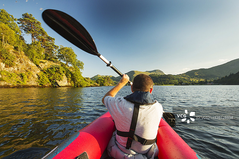 中年男人在英国湖区乌尔斯沃特湖上划充气皮划艇图片素材