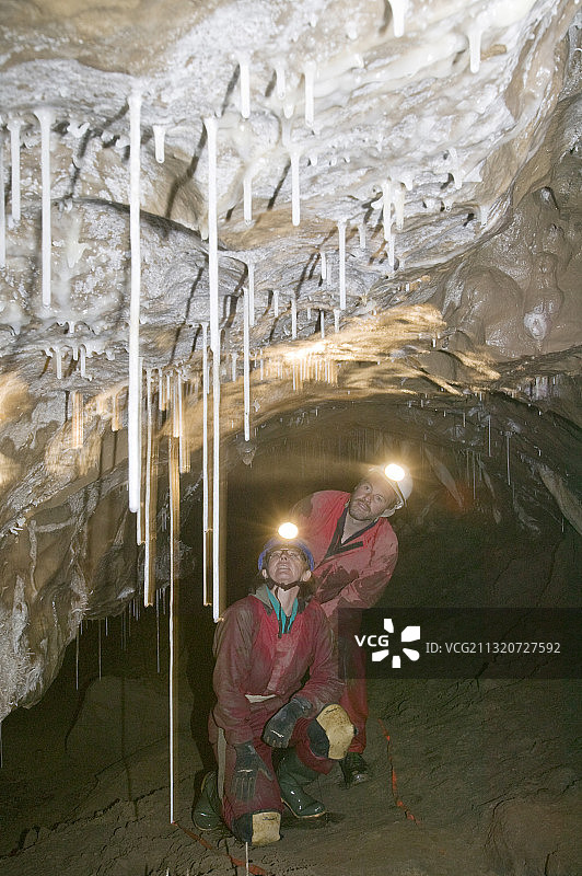 英国约克郡山谷莱克费尔诺茨II洞穴中观察石笋的洞穴探险者图片素材