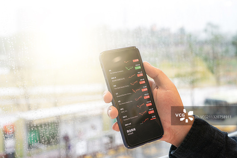男性使用智能手机进行股票交易图片素材