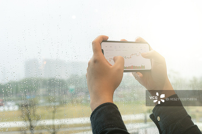 男性使用智能手机进行股票交易图片素材