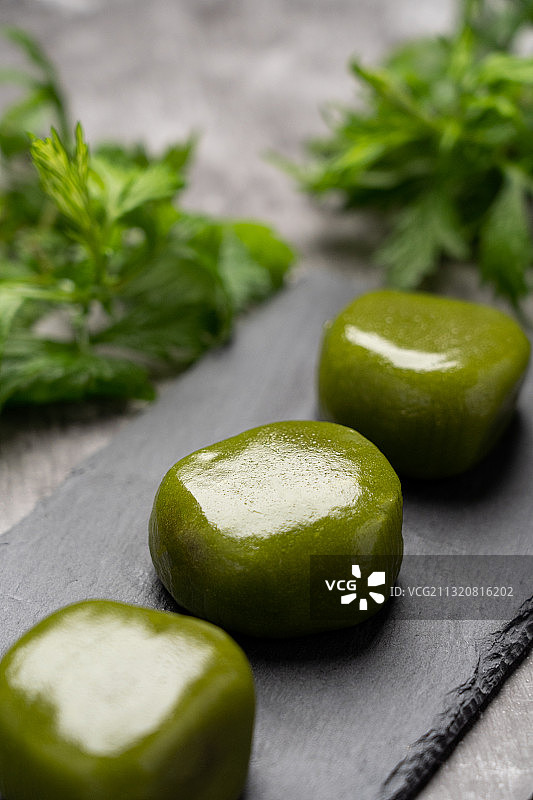 低调灰色背景清明小吃点心美味艾饼糍粑青团和原材料艾草艾叶图片素材